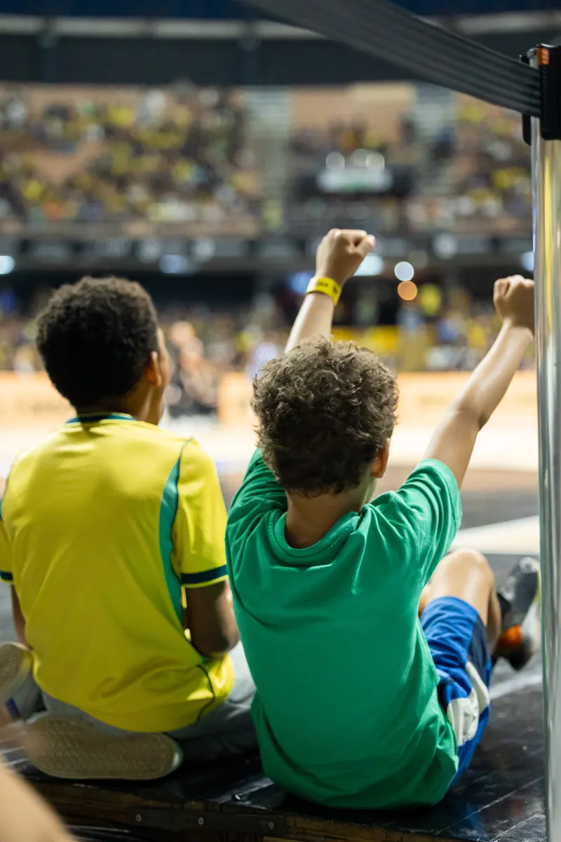 Two young fans in Brazil shirts celebrating courtside