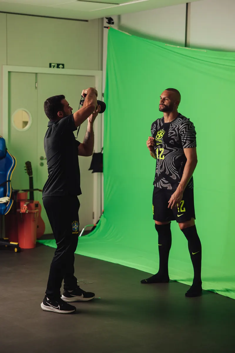 Matheus Maranhão photographing a Brazil player against a green screen